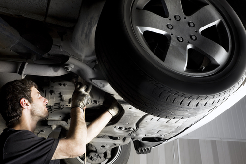 Technician inspecting a wheel and suspension
